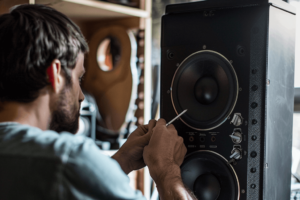 gefen_23233_a_man_fixing_a_speaker_with_a_blank_bright_backgrou_c24187b7-f649-4aa2-be20-91126a00707d-2